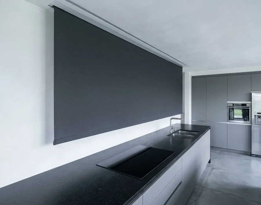 Concealed roller blind dropping from a recessed ceiling pocket with no visible headbox above the glass